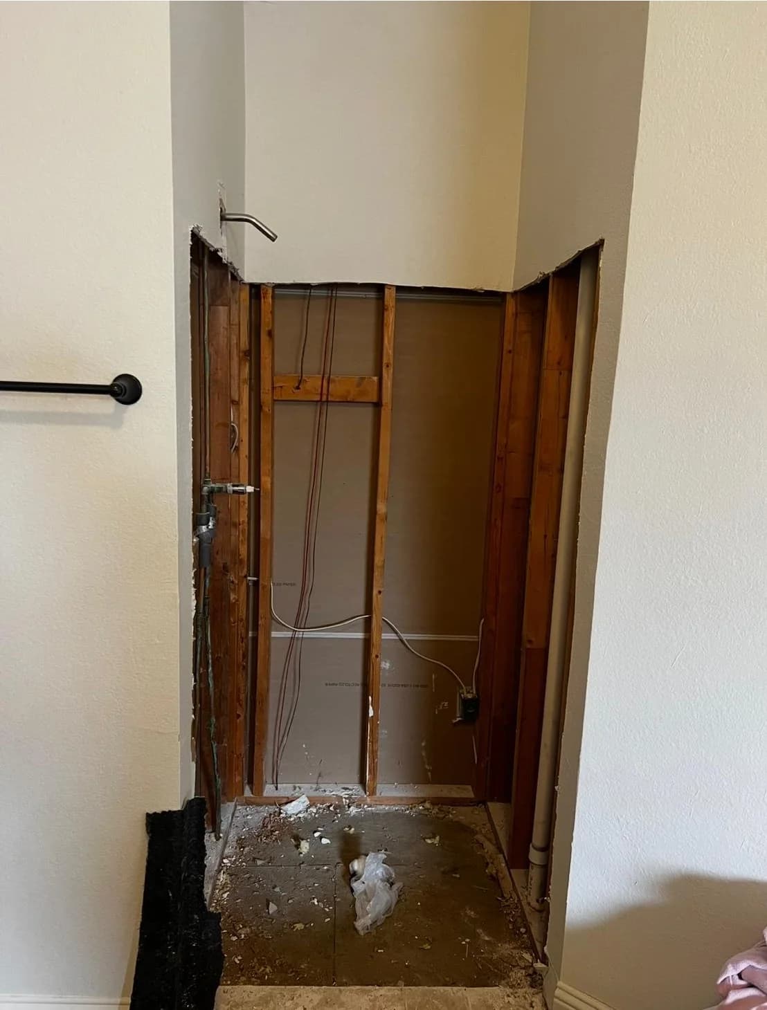 The shower alcove stripped back to bare studs with the pan removed